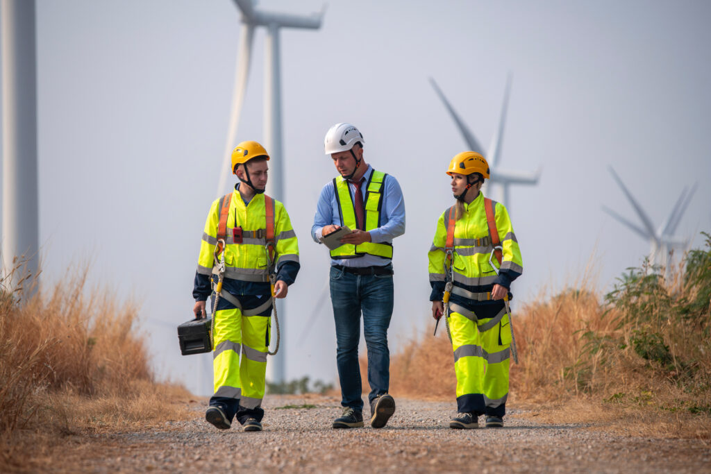 Engineer surveyors do an inspection in a wind turbine farm