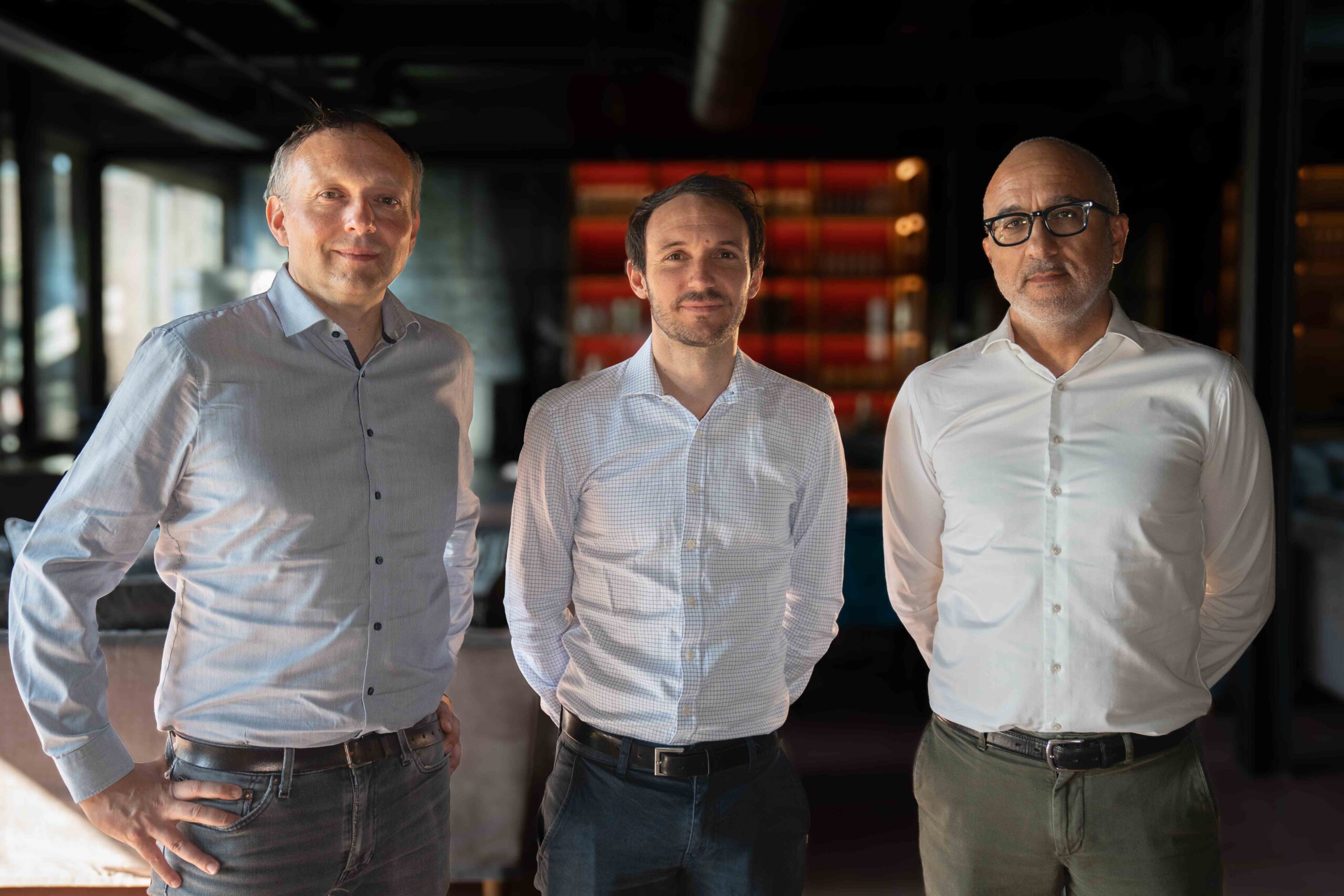 Group photo of three men in light button down blouses